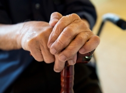elderly person's hands on walking cane