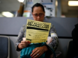 An attendee at a health insurance enrollment event in Cudahy, California reads a leaflet, March 27, 2014