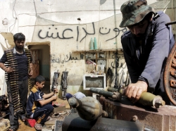 Iraqi volunteers fix weapons for the Hashid Shaabi militia at a shop on the outskirts of Basra, June 16, 2015