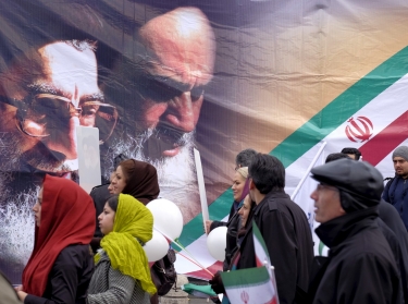 People pass a large picture of Iran's Supreme Leader Ayatollah Khamenei and the late leader of the Islamic Revolution Ayatollah Khomeini during a ceremony marking the 37th anniversary of the Islamic Revolution, in Tehran, February 11, 2016