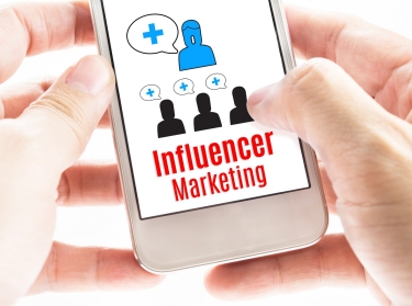 Person holding a smartphone displaying influencer marketing