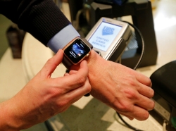 A man uses an Apple Watch to demonstrate the mobile payment service Apple Pay at a cafe in Moscow, Russia, October 3, 2016