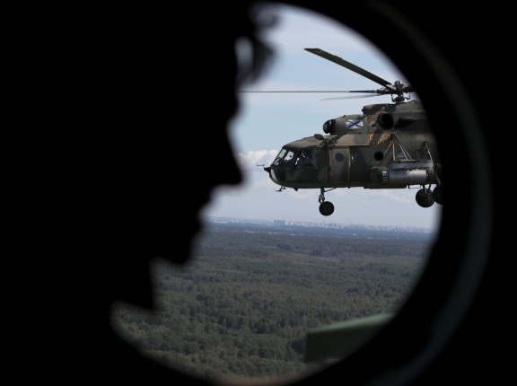 A Russian Mi-8 military helicopter is seen through a window while flying during a rehearsal for the Navy Day parade in Saint Petersburg, Russia, July 21, 2019, photo by Anton Vaganov/Reuters