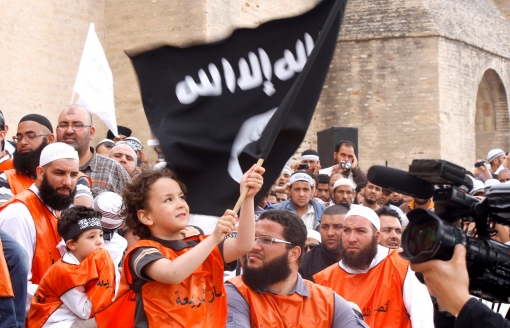 A young boy waves a black flag inscribed with Islamic verses at a rally of Tunisian Salafi Islamists in the central town of Kairouan, May 20, 2012