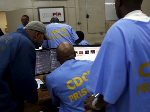 Prisoners gather around a computer following a graduation ceremony from a computer coding program at San Quentin State Prison in San Quentin, California, April 20, 2015