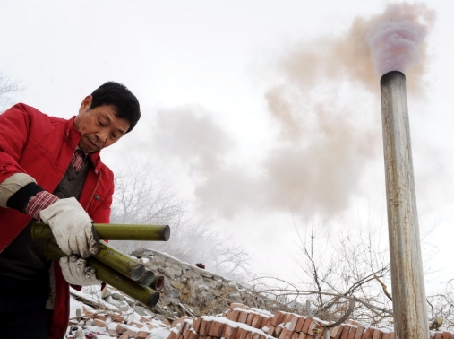 A Chinese meteorological department worker burns catalyst for cloud seeding and snowmaking, aiming to help end a drought in Beijing, China, February 17, 2009