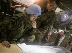 Members of the Japan Ground Self-Defense Force and a U.S. Army captain examine a field artillery safety diagram at Yausubetsu Training Area, Japan, photo by U.S. Army