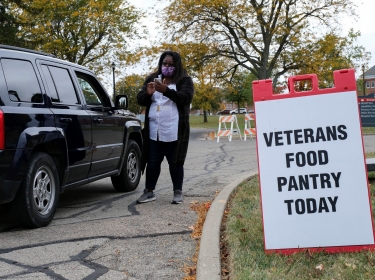 A worker checks the identification of a veteran receiving aid at food bank in Dayton, Ohio, October 15, 2020, photo by Jeffrey Dean/Reuters
