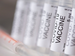 Detail of covid-19 vaccine vials and and a syringe. Photo by vladans / Getty Images