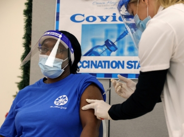 Denise Gregory, a staff member at Crown Heights Center for Nursing and Rehabilitation, a nursing home facility, receives the COVID-19 vaccine from Walgreens Pharmacist Annette Marshall, in Brooklyn, New York, December 22, 2020, photo by Yuki Iwamura/Reuters