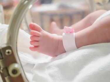 Close up of a newborn leg viewed through an incubator, photo by Kwangmoozaa/Getty Images