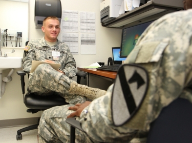 Spc. Jack Buckwalter, a mental health specialist, provides triage to a soldier during a behavioral health assessment.