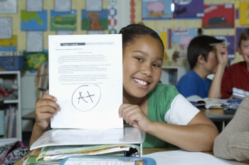 A student holds up her paper.