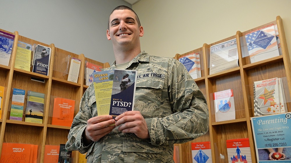 A mental health technician holds PTSD resource brochures