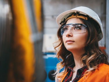 Portrait of young engineer woman working in factory building, photo by serts/Getty Images