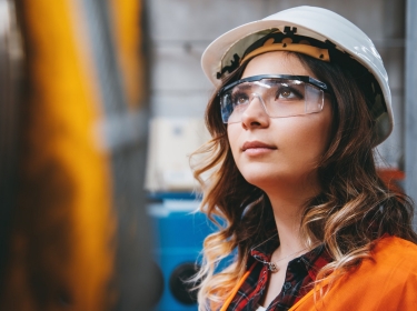 Portrait of young engineer woman working in factory building, photo by serts/Getty Images