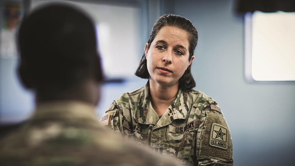 A female soldier a listens to another soldier