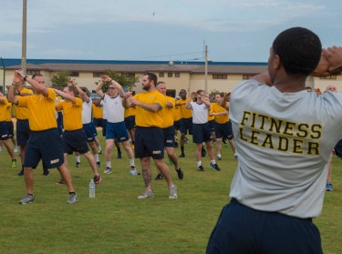 Sailors assigned to the amphibious assault ship USS Iwo Jima (LHD 7) perform knee-blockers during command physical training at Naval Station Mayport