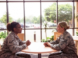 Two U.S. Air Force mental health professionals talk in a hospital reception area