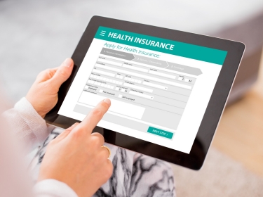 A health insurance application on a tablet, photo by grinvalds/Getty Images