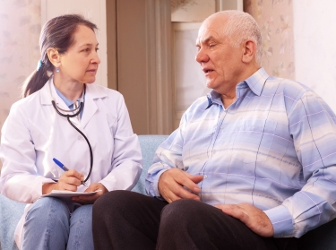 older man speaking with female doctor