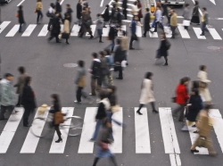 People cross a city street on their way to work