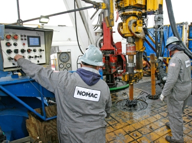 Workers prepare to change drilling pipes on the rotary table of a natural gas rig near Towanda, Pennsylvania, February 3, 2010
