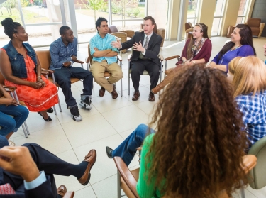 Man talking to a diverse group of people during a therapy session