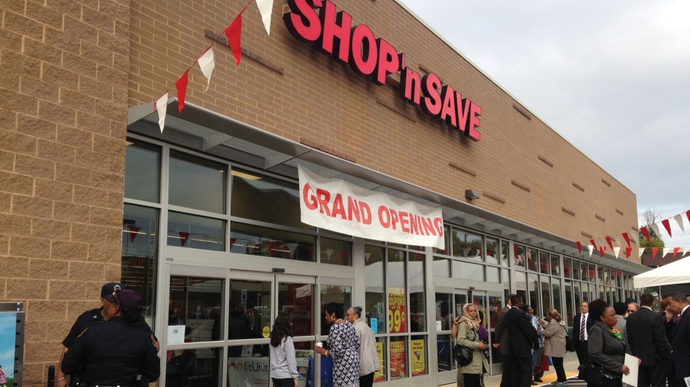 People gather outside the grand opening of a Shop 'n Save grocery store