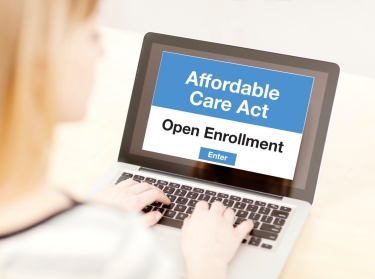 Woman on laptop enrolling in insurance plan through the Affordable Care Act site