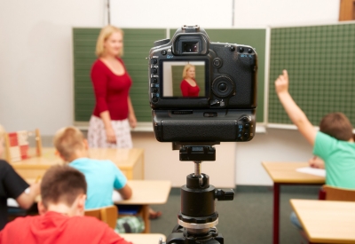A camera takes pictures as a teacher speaks to her students
