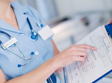 Close up of a nurse looking at a patient's medical chart