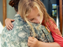 Female soldier hugging a child