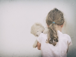 A young girl holding a teddy bear