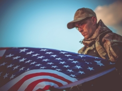 Young military veteran with American flag in the foreground