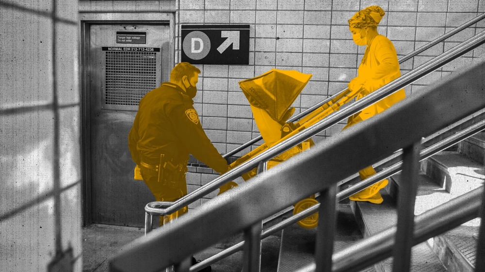 A police officer helps a woman with a baby stroller on the stairs to a subway platform