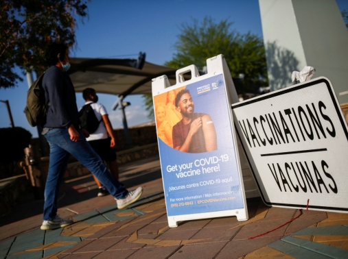 People walk past a COVID-19 vaccination center near the Santa Fe International Bridge, in El Paso, Texas, May 7, 2021