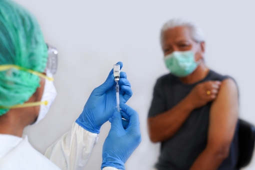 A health care worker prepares to administer a vaccine