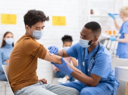 Asian male patient getting vaccinated against coronavirus in hospital
