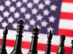 Chess pieces in front of an American flag