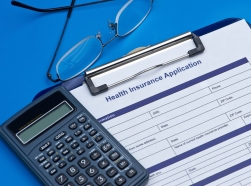 Health insurance application with glasses and calculator