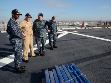 Vice Adm. Thomas S. Rowden, commander of Naval Surface Forces, surveys work done on the flight deck of the amphibious assault ship USS Boxer (LHD 4) during a visit