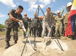 Philippine Army Lt. Col. Henry Bellan (left) and U.S. Army Lt. Col. John Garrity (right) bury a time capsule during a groundbreaking ceremony in San Narciso, Philippines, March 18, 2013