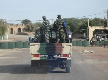 Malian soldiers ride in the back of a truck in Timbuktu, January 2015