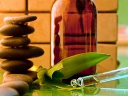 Alternative medicine: hot stones, medicine bottle, herbs, and eyedropper