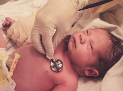 Doctor checking newborn baby's heart rate