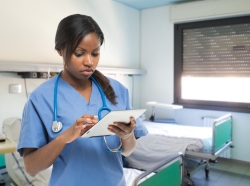 Nurse using a tablet in a hospital room