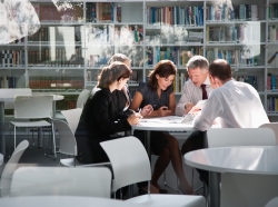 Business people meeting in a library, seen from outside a window