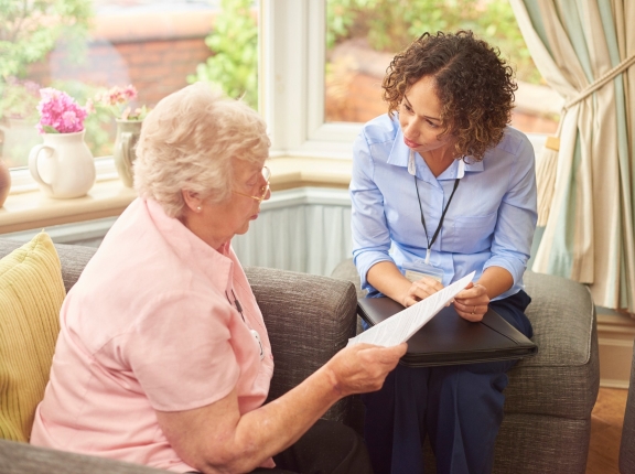 Home health worker speaking with elderly woman in her home