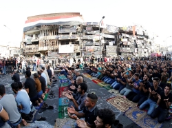 Sunni and Shi'ite Muslims attend prayers during Eid al-Fitr as they mark the end of the fasting month of Ramadan, at the site of a suicide car bomb attack over the weekend in Baghdad, Iraq, July 6, 2016